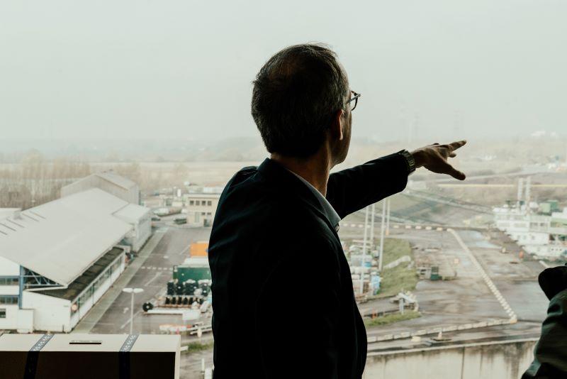 Luc Vandenbulcke op zijn kantoor met zicht op windmolens