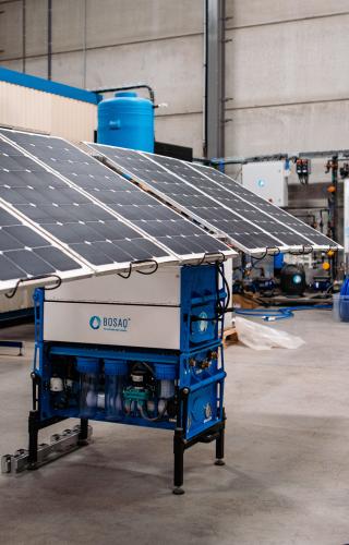 Twee medewerkers kijken op een mobiele drinkwaterzuiveringsinstallatie