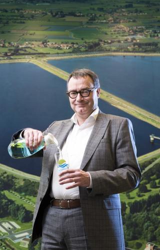 Hans Goossens die een glaasje met water vult