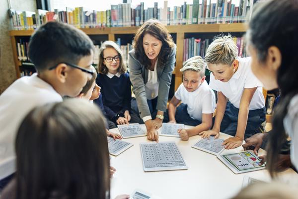 Leerkracht met tablet voor de klas