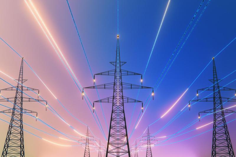 Een kleurrijke en futuristische foto van elektriciteitsmasten met lichtgevende kabels – symbolisch voor de drukte en spanning op het stroomnet (netcongestie)