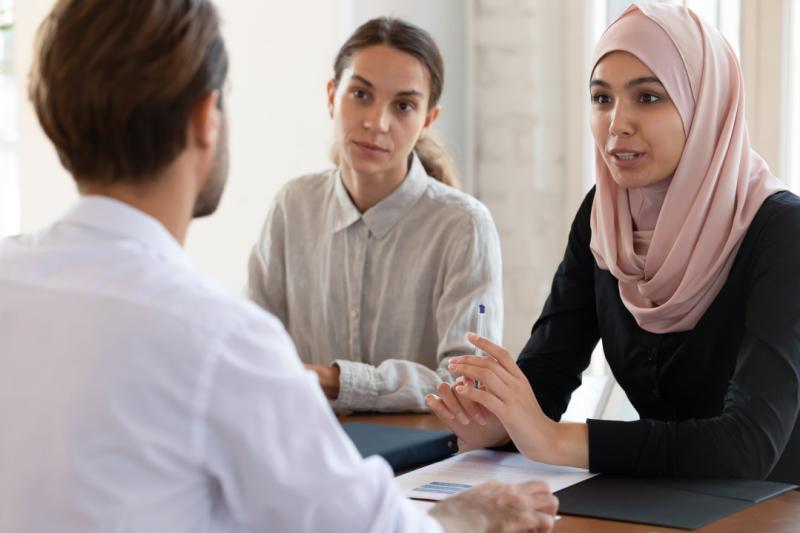 vrouw met hijab in gesprek met man en vrouw