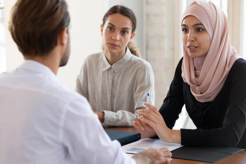 vrouw met hijab in gesprek met man en vrouw
